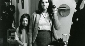 Sur la photo, la comédienne Hélène Loiselle est arrêtée par deux policiers, sa petite fille blottie contre elle dans le film Les Ordres (Collection Cinémathèque québécoise)